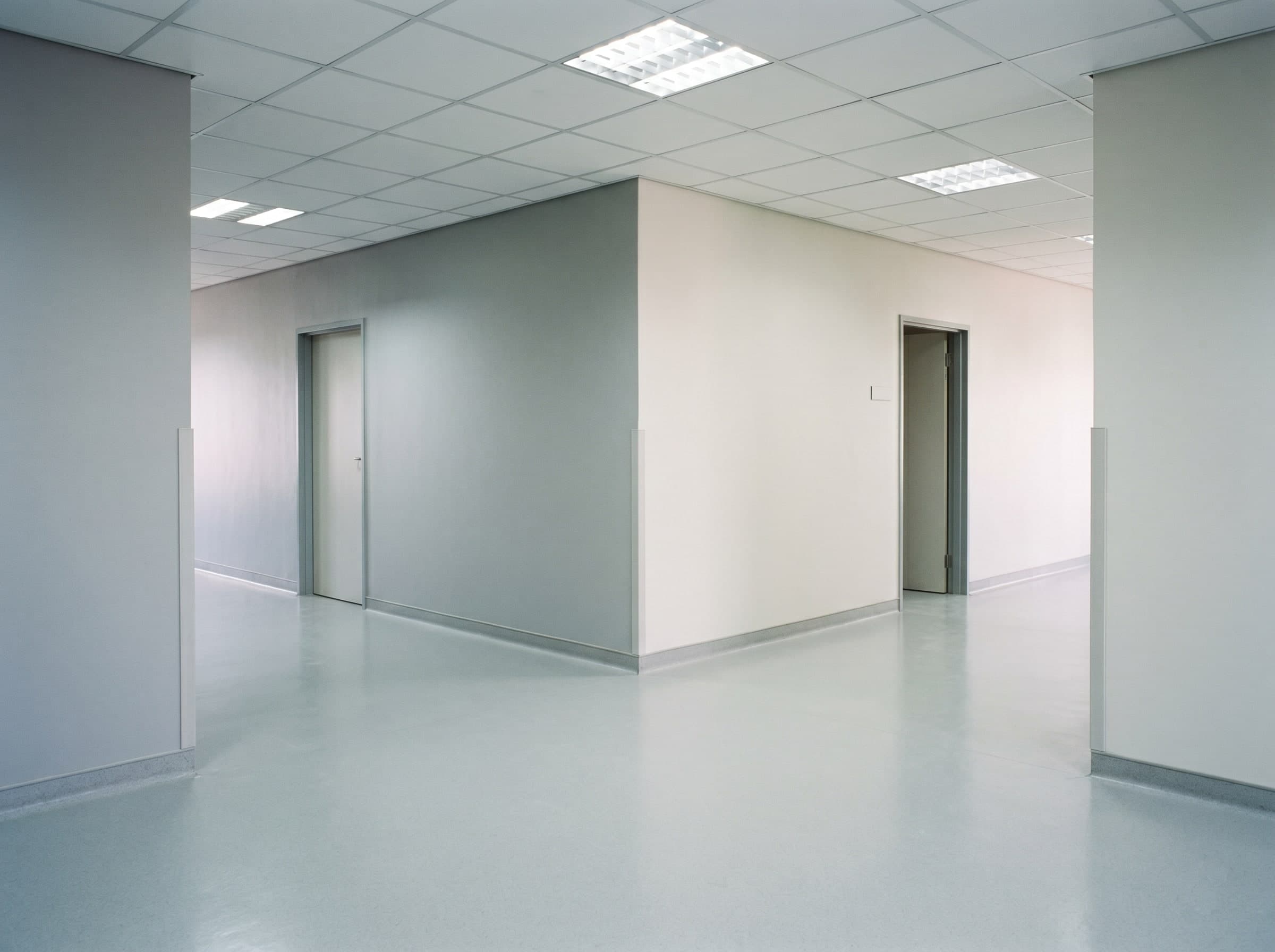 Completed empty hospital wing corridor intersection with resin floors and wall coatings in Gauteng