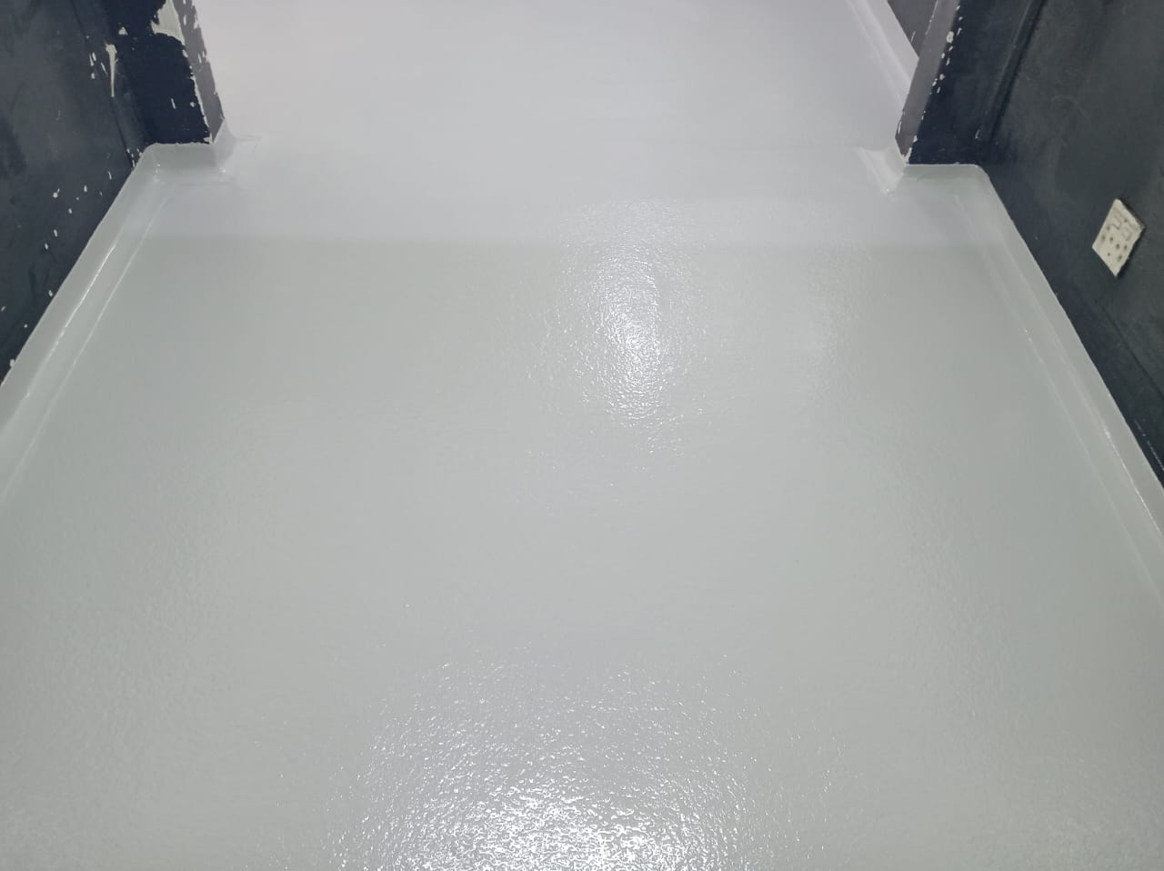 Torch-on flat roof waterproofing with UV protection course on a commercial building