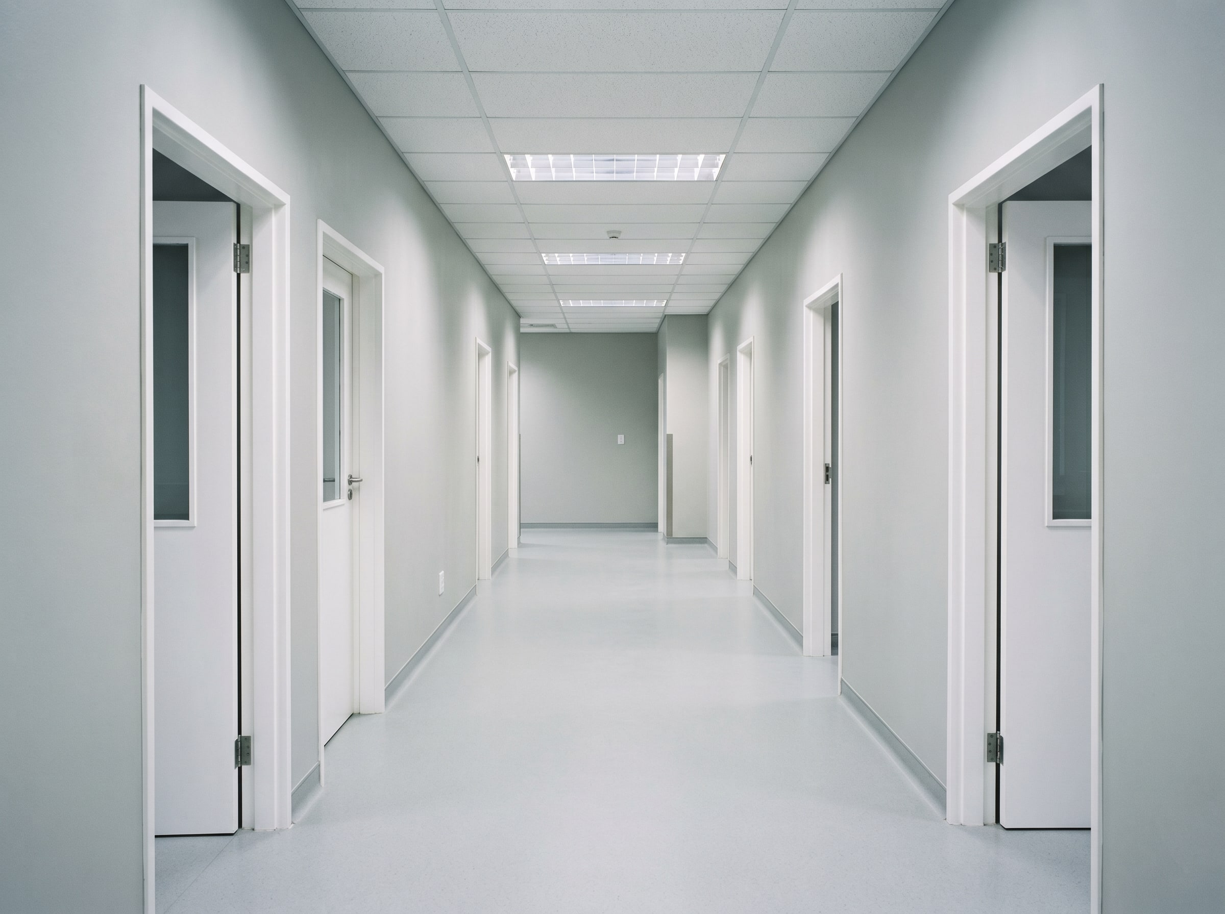 Completed wall coatings and seamless resin flooring in a new empty hospital corridor in Gauteng