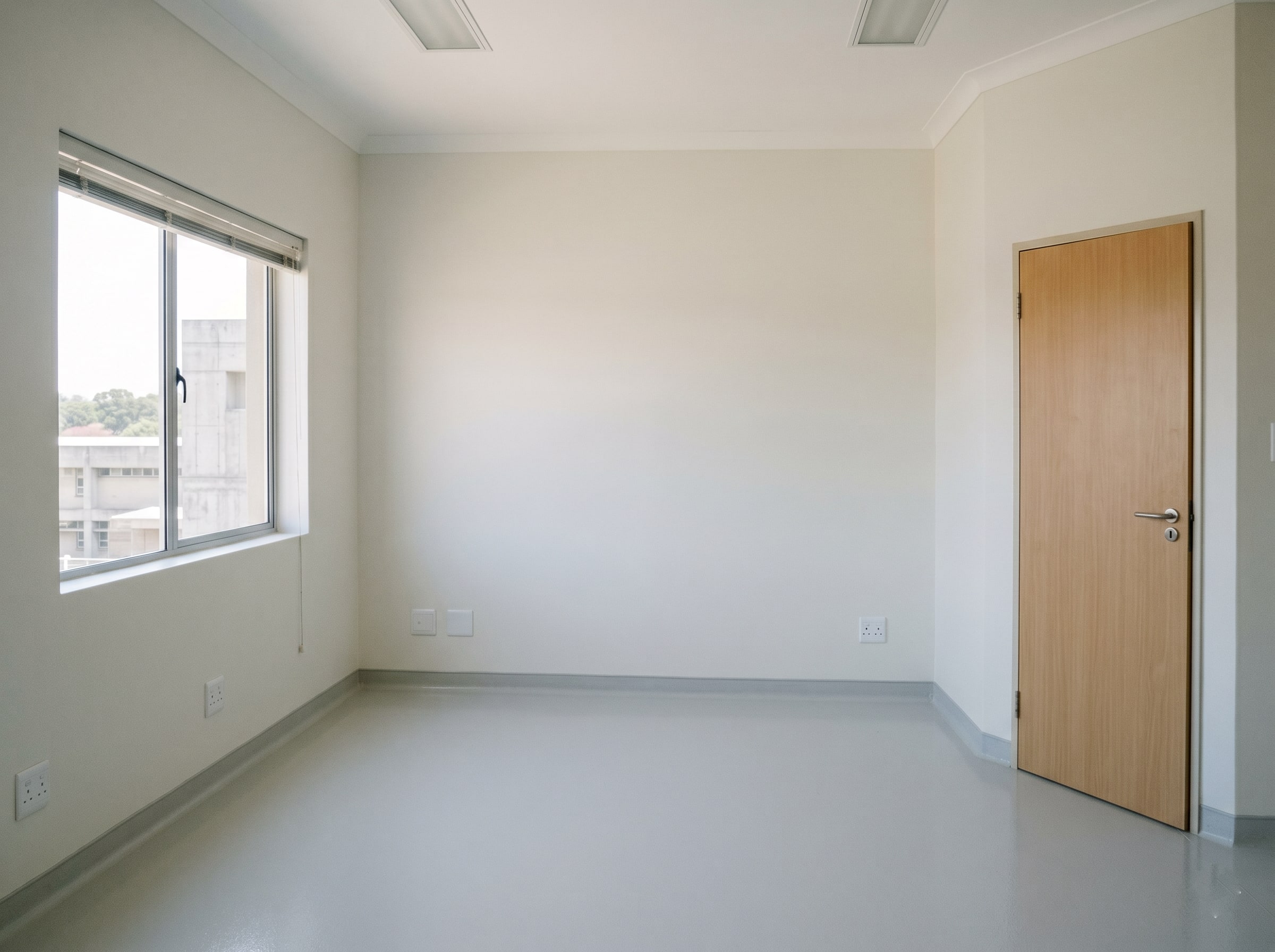 Completed antimicrobial wall paint and resin floor in an empty new hospital patient room