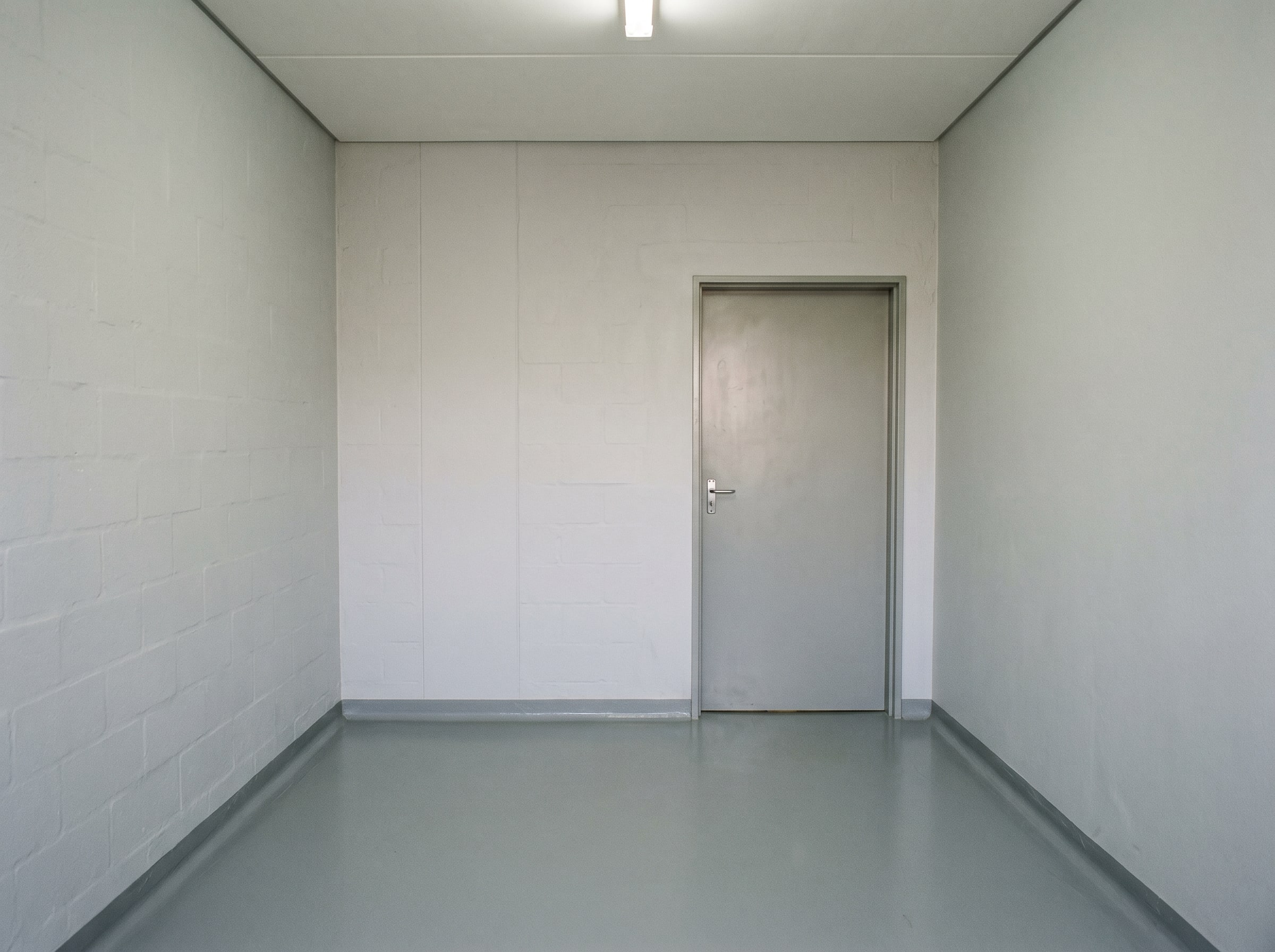 Completed paint and resin floor handover in an empty hospital storage room in Gauteng