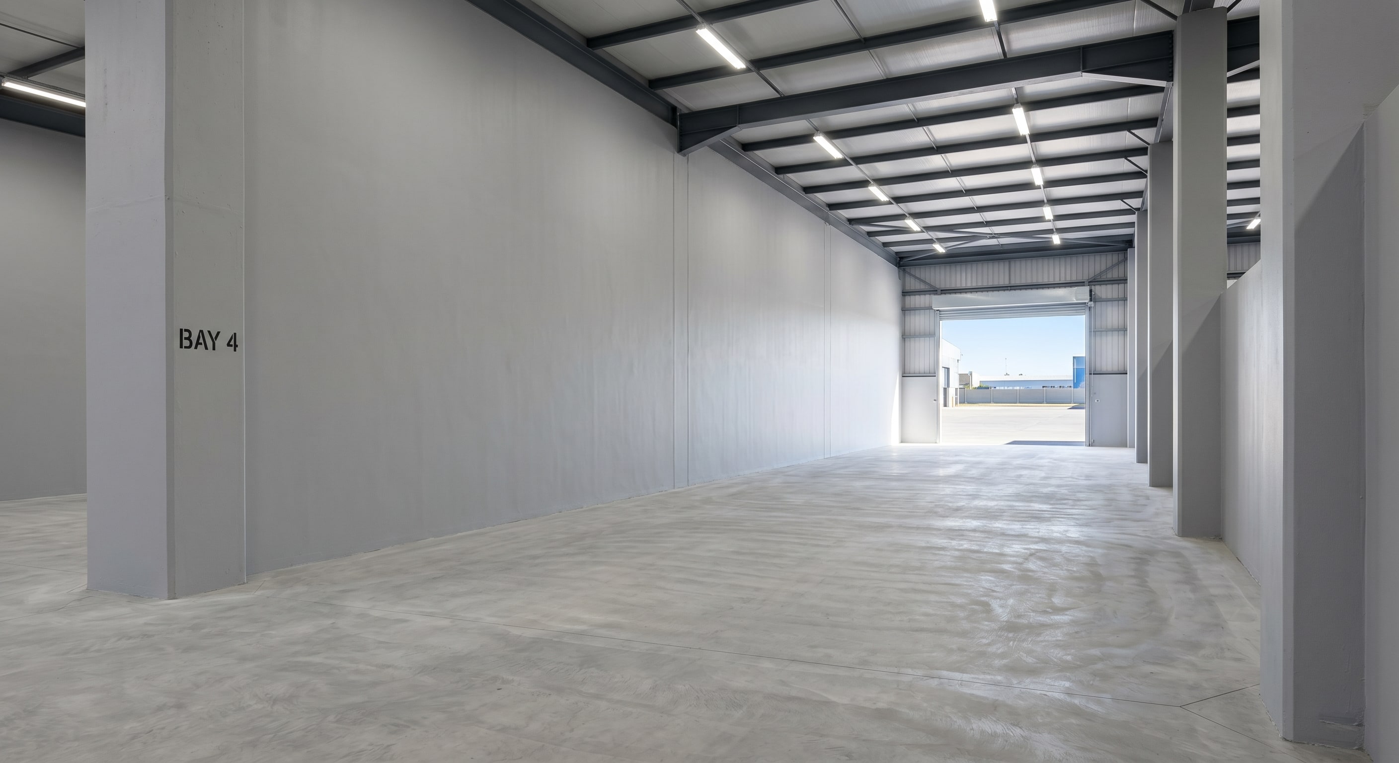 Completed airless spray wall coating in an empty Gauteng warehouse bay
