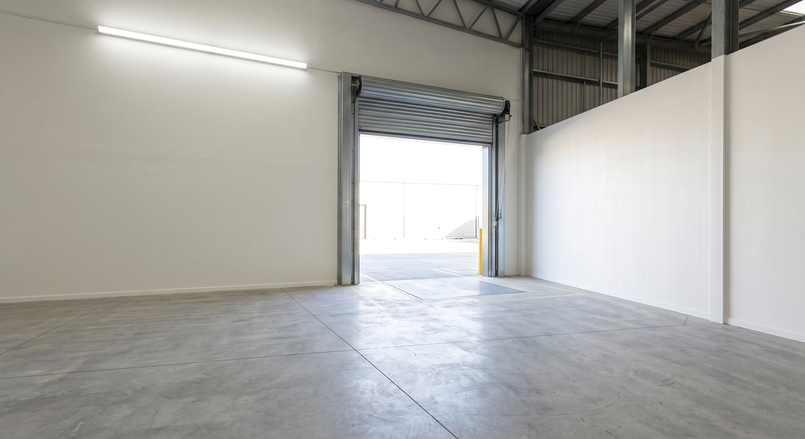 Close-up of completed airless spray coating on concrete block warehouse walls