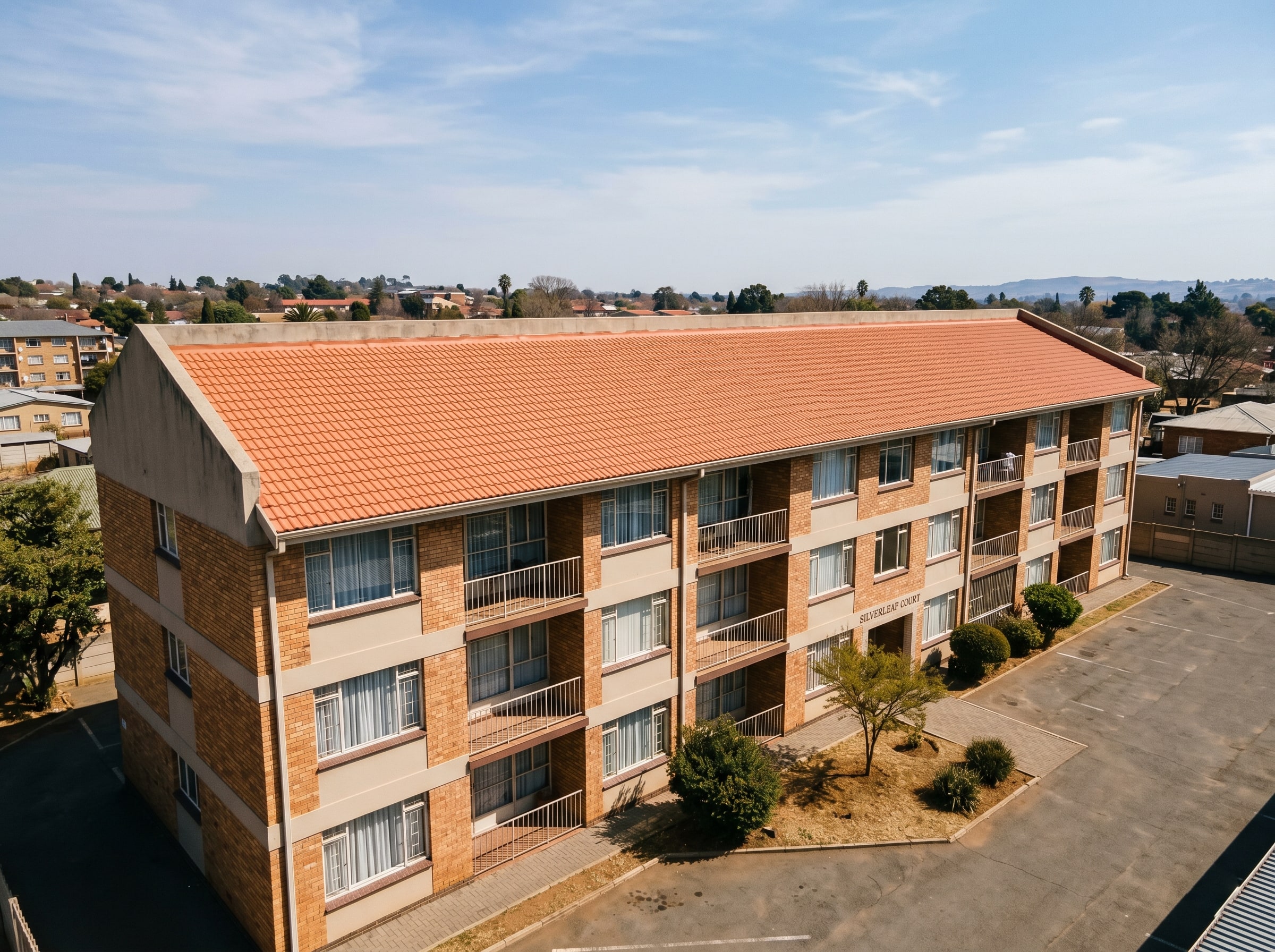 Completed tile roof coatings on a row of Gauteng townhouses
