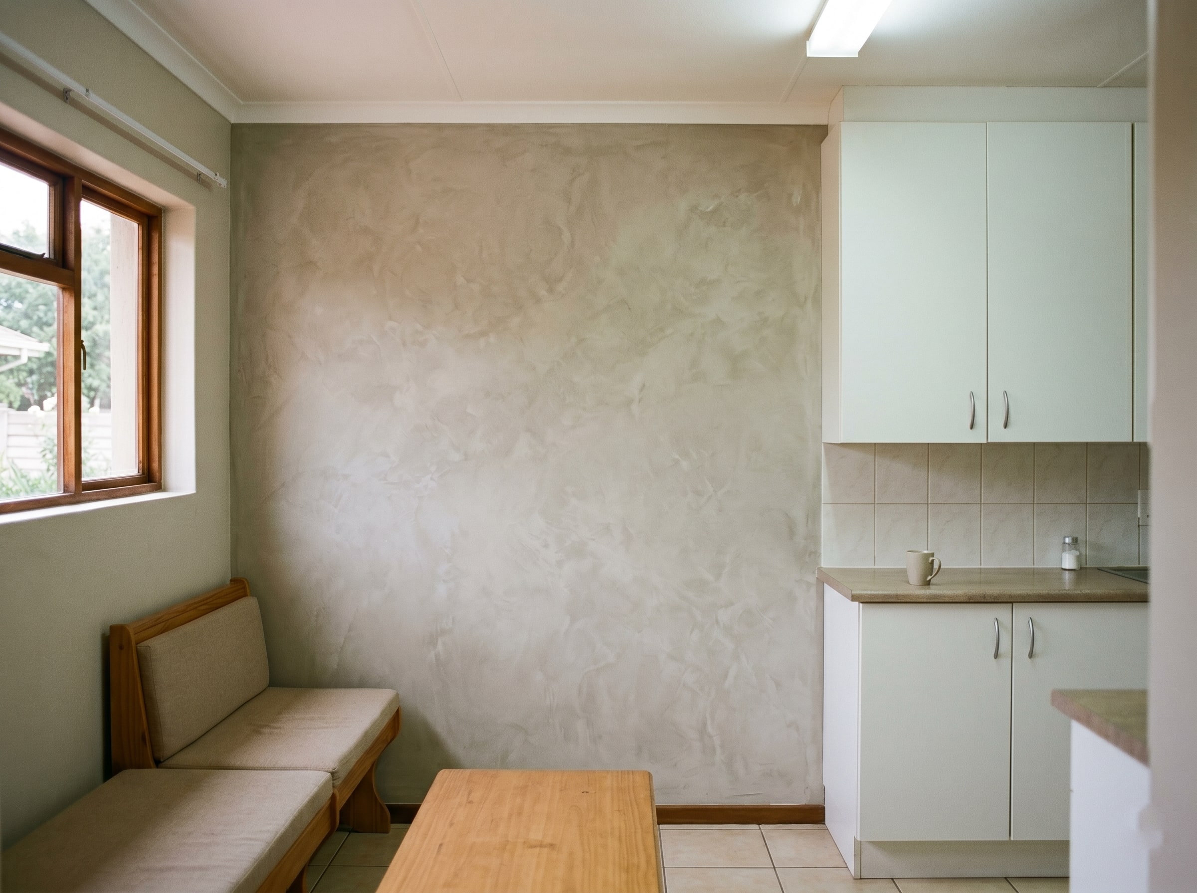 Completed warm sand interior stucco in a foyer opening into the living room