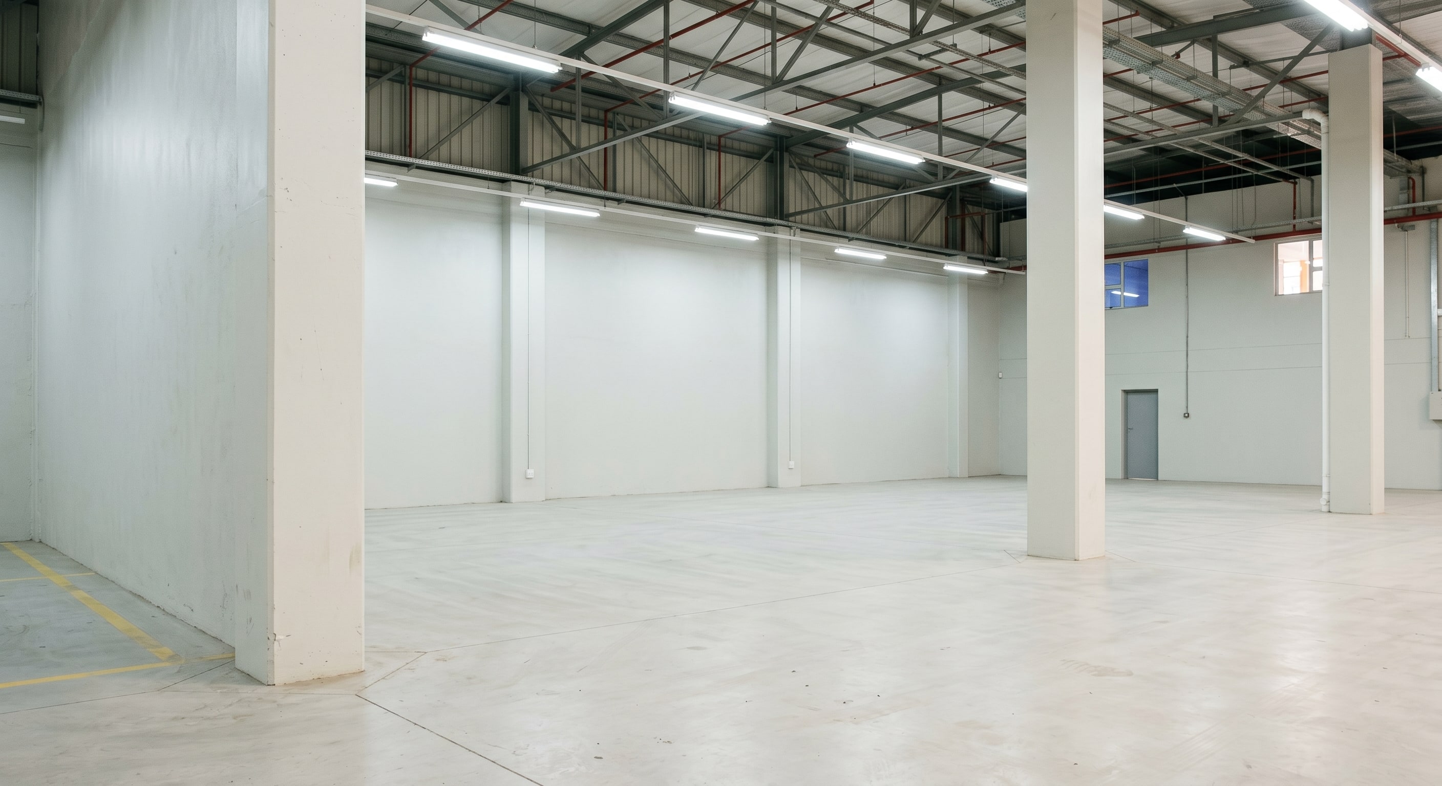 Completed light-reflective interior wall coatings in an empty Gauteng warehouse bay