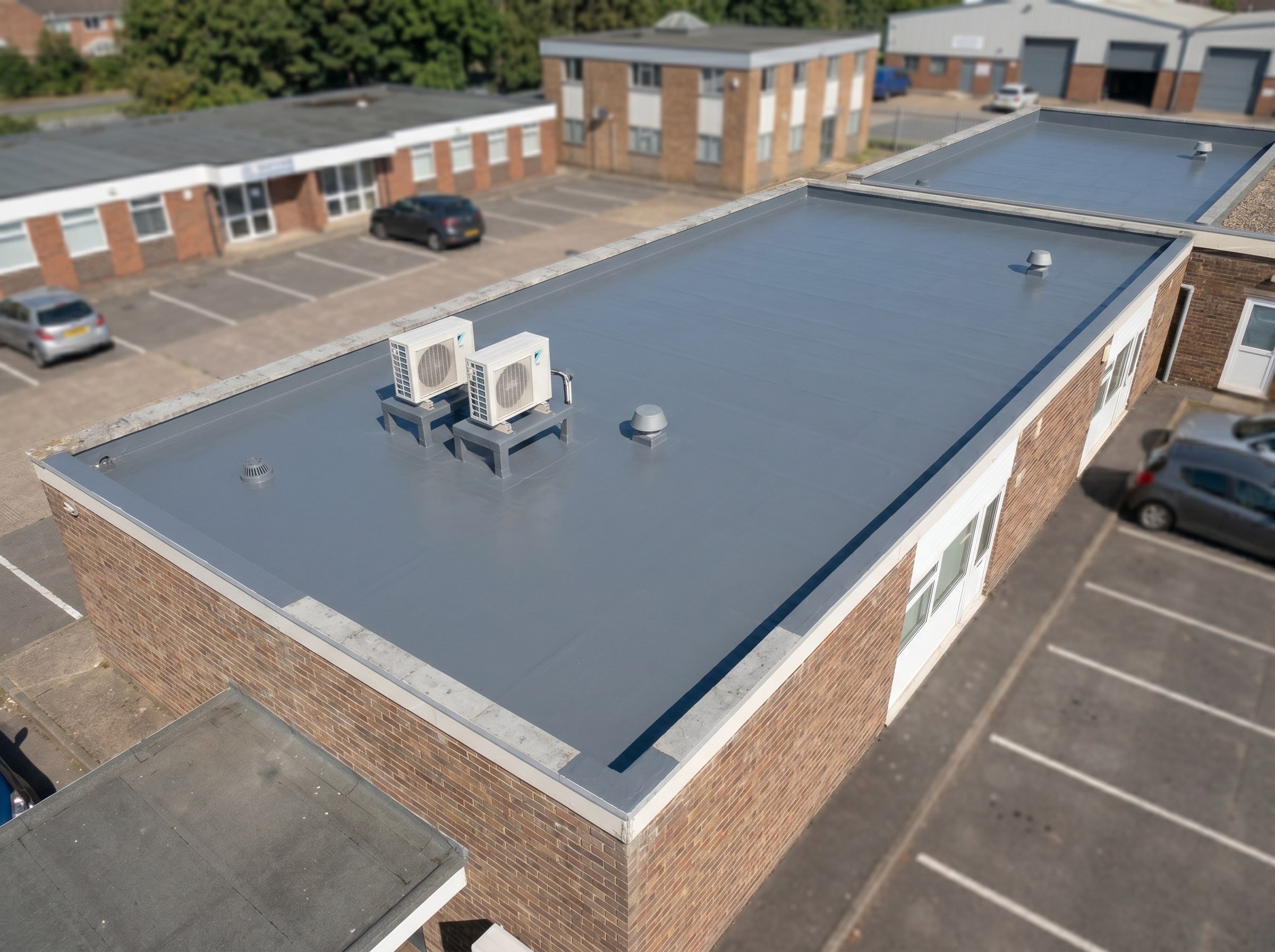Finished flat roof with flashed AC bases on a small office strip