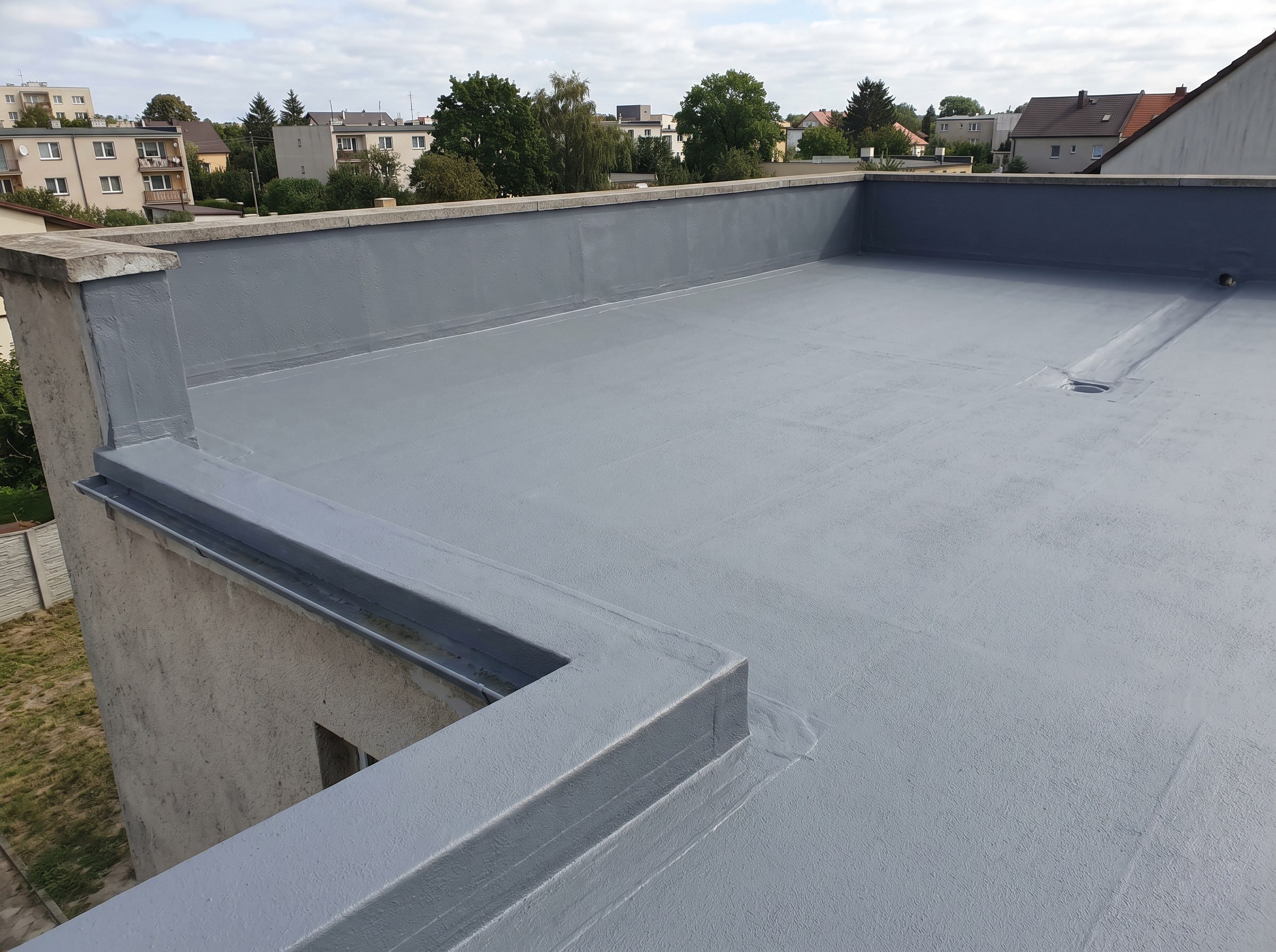 Finished grey liquid-applied membrane on a modest flat roof section